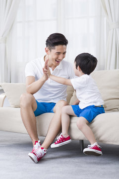 Father and son playing on the sofa