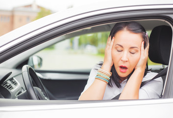 Woman driver holding her head in disbelief 