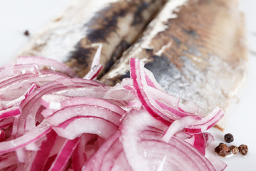 Salted herring on the plate with red onion