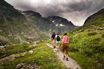 An family is taking a walk in the Swiss alps under dark clouds