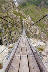 Fototapeta premium Trift Bridge is the longest pedestrian-only suspension bridge in the Alps, 170 m in length and traversing a height of 100 m. The bridge spans the lake, Triftsee, near Gadmen, Switzerland