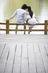 Young couple sitting by lake