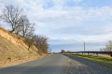 Asphalt rural road with trees and beautiful sky