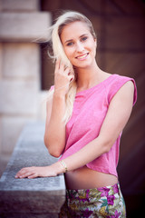 Blog style beautiful brunette woman in fashionable dress posing in park presenting garment
