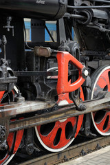 Train drive mechanism and red wheels of an old  steam locomotive