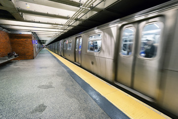train on New York City subway with homeless sleeping on the platform