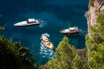 Three boats docked in a small bay in Capri