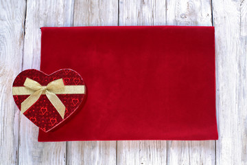 Heart gift box  on red velvet and wooden background 