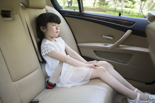Little girl sleeping in car back seat