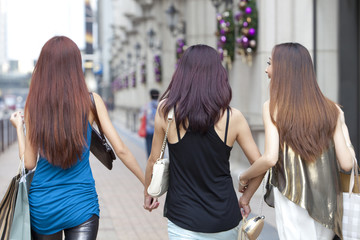 Fototapeta premium Cheerful best female friends go shopping in Hong Kong