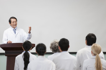 Senior doctor giving speech in boardroom