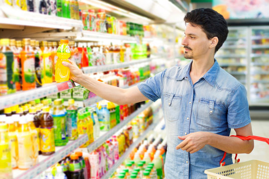 man in a supermarket buying a bottle of juice