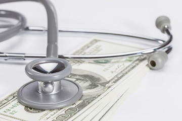 Stethoscope on a pile of money, depicting the health care indust