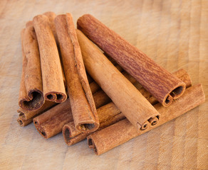Heap of the cinnamon sticks on the wooden background