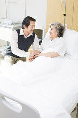 Obraz premium Senior man taking care of wife in hospital