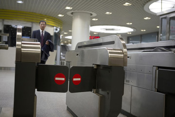 A Man Approaching The Ticket Gates At A Subway Station