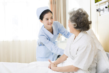 Obraz na płótnie Canvas Nurse taking care of senior woman in hospital