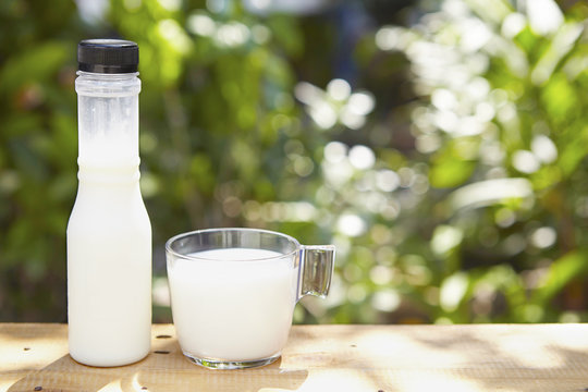 Milk in bottle and in glass on the table outdoor 