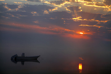 Fototapeta na wymiar Boat and fog during sunrise