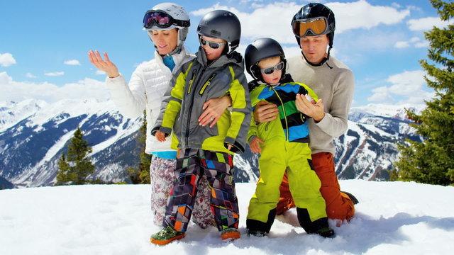 young Caucasian family parents boys outdoor snow ski recreation teamwork 