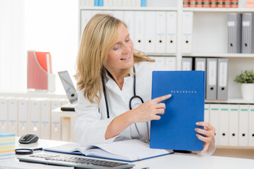 ältere attraktive medizinerin zeigt auf bewerbung