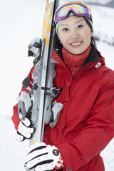 Woman Standing On Ski Field, Holding Skis