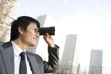 Businessman Holding Hand-Held Telescope