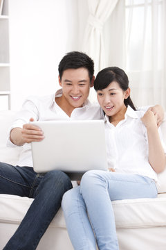 Young couple using laptop in sofa