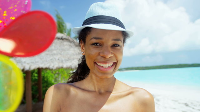 Young African American girl wearing bikini with toy pinwheel on beach