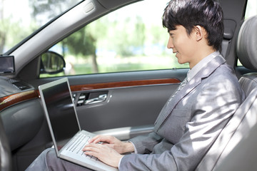 Businessman surfing the net inside car