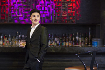 Young man having a drink at bar