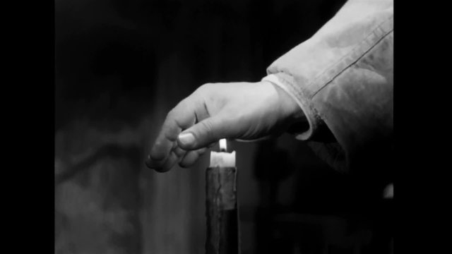 Man extinguishing candle with his bare hand, 1940s