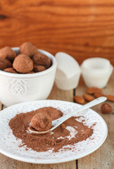 Homemade chocolate truffles with cocoa powder on a white plate