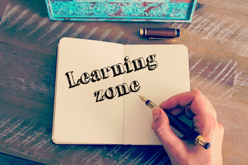 Motivational message LEARNING ZONE written on notebook