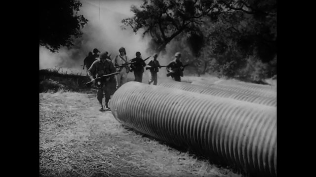 Soldiers running into large tubes during combat training