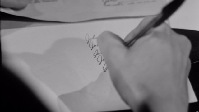 Close-up of woman forging man's signature on document