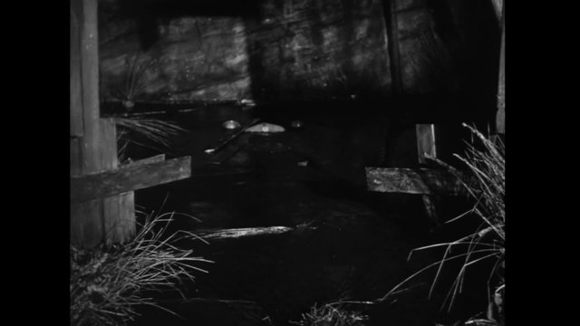 Pick-up truck sinking in barn, 1940s