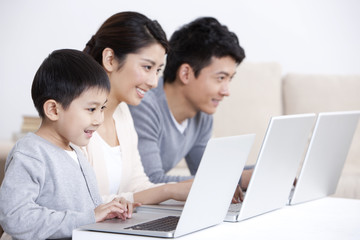 Young family surfing the net with laptop