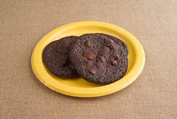 Chocolate chip crispy brownie cookies on yellow plate