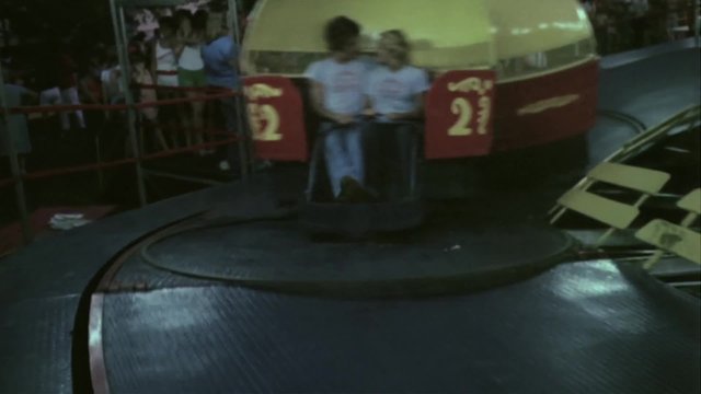 People enjoying the Tilt-A-Whirl ride at amusement park