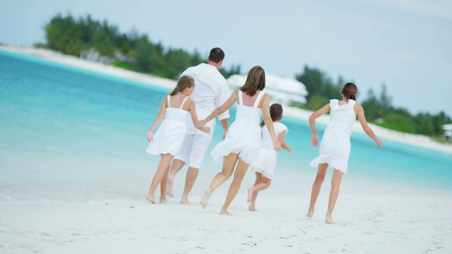 Caucasian family parents girls white clothes beach ocean island vacation tourism