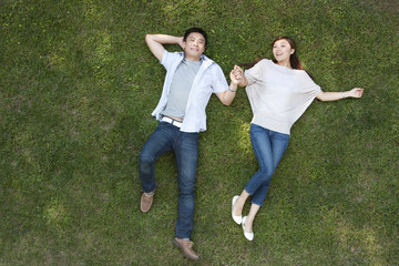 Young Chinese couple lying on the grass