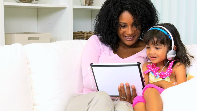 young African American mother female pre school child playing tablet together