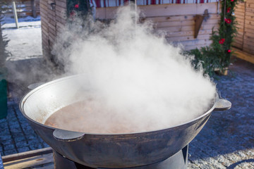 Large vat of steaming stands on the street