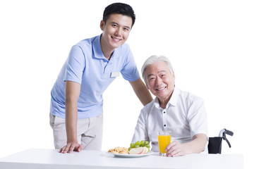 Disabled senior man having breakfast in nursing home
