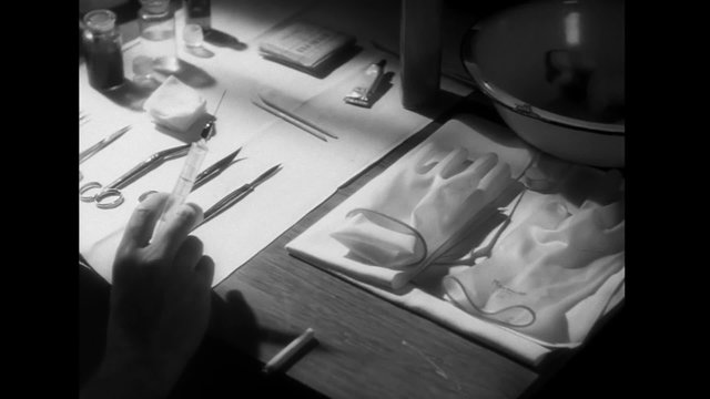 Man picking up syringe and scalpel while smoking cigarette, 1940s