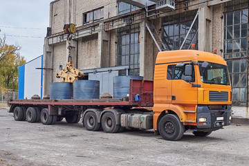 Cranes unloading a freight transport with still rolls