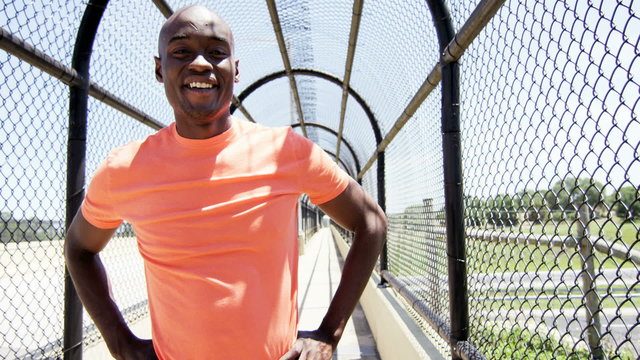 Young active African American guy doing fitness activity on bridge outdoor