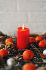Красная свеча с шишками и мандаринам