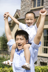 Father carrying son on shoulder